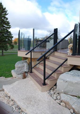 Wood steps with a glass railing are beautiful set into the stone landscape